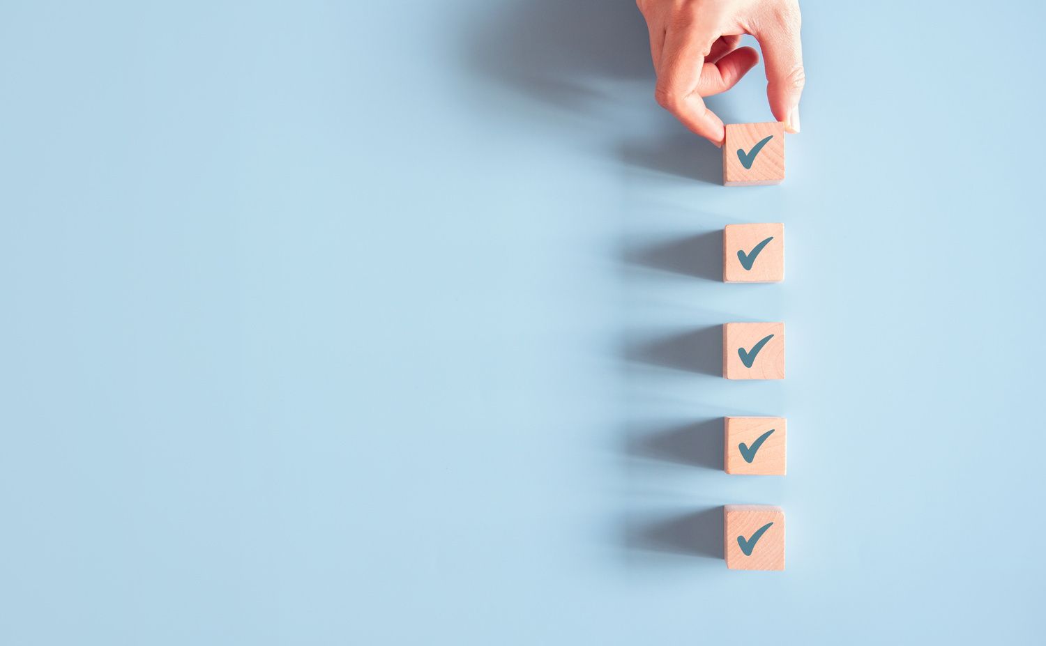 Wood cube with check mark on blue background, Checklist concept, Copy space.